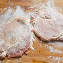 Приправленные шницели посыпаем пшеничной мукой, стряхиваем лишнюю муку.