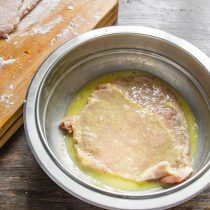 Кладем шницель в миску, приподнимаем, чтобы стекло все лишнее и остался тонкий яичный слой.