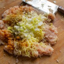 Добавляем нарезанный лук-порей к фаршу и картофелю.