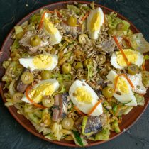 Посыпаем салат жареными семечками, добавляем разрезанные пополам оливки.