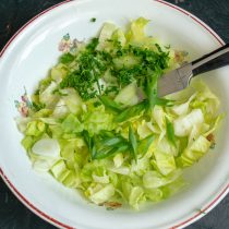 Добавляем к айсбергу мелко нарезанную зелень петрушки и зелёный лук.