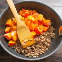 Сдвигаем обжаренный фарш в сторону, кладем нарезанную тыкву. Сдвигаем обжаренный фарш в сторону, кладем нарезанную тыкву.