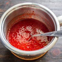 В кипящее клубничное пюре тонкой струйкой вливаем тщательно перемешанную воду с крахмалом.