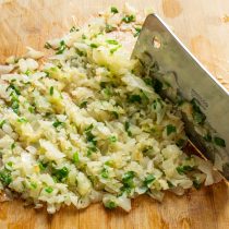 Мясным топориком или широким острым ножом рубим капусту несколько минут. Мясным топориком или широким острым ножом рубим капусту несколько минут.