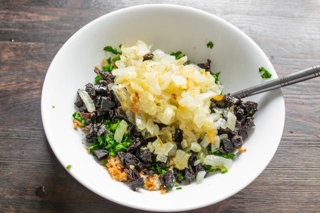 Лук мелко нарезаем кубиками и пассеруем на смеси сливочного и растительного масла до мягкости, после чего добавляем его в начинку.