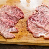 Начинку делим пополам, выкладываем на отбитое мясо. Разравниваем начинку по отбивной так, чтобы по краям оставалось свободным примерно пол сантиметра