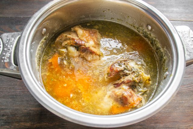 Голени складываем в кастрюлю с перцем, лавром, луком, чесноком и петрушкой. Заливаем водой, солим, доводим до кипения и томим 2,5 часа. За 20 минут добавляем морковь. Оставляем индейку остывать в бульоне.