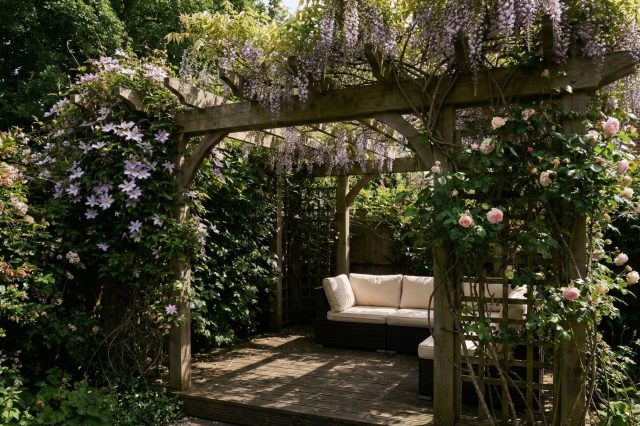 Пергола с вьющимися растениями — это изящный способ нарастить высоту забора без глухих стен. Она создает уютный зеленый шатер, который защищает от взглядов сверху и превращает обычную границу участка в зону отдыха.