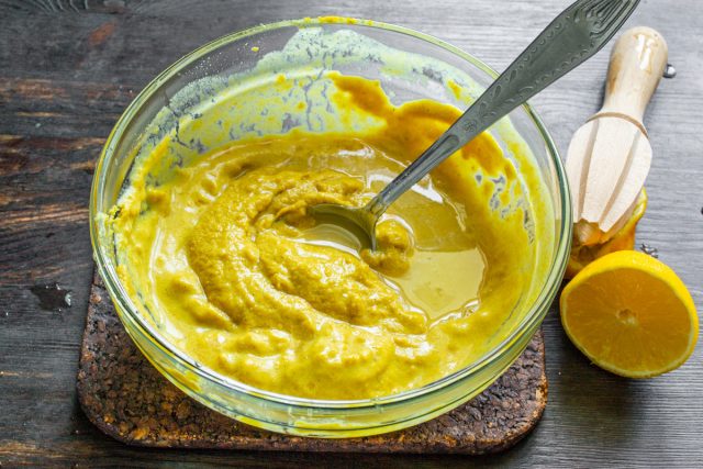 Подготавливаем и вводим кислый компонент. Выжимаем сок из половины лимона, обязательно процеживаем его от косточек и сразу вливаем в горчичную основу.