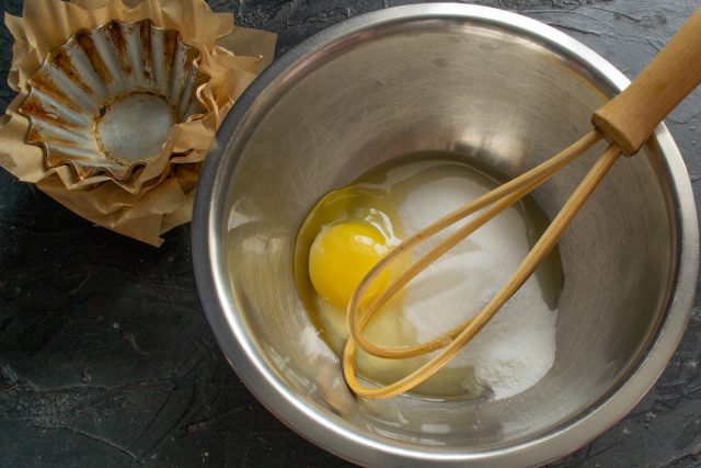 Начинаем приготовление теста: в глубокую миску насыпаем сахарный песок и разбиваем одно куриное яйцо.