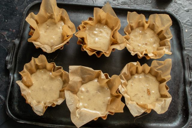 Раскладываем отдохнувшее тесто по подготовленным формочкам с бумажными вкладышами.