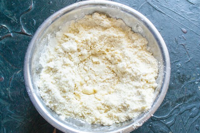 Перетираем масло с мукой руками в крошку, делаем в центре углубление. Вливаем холодное молоко или воду, чтобы быстро связать сухие ингредиенты в тесто.