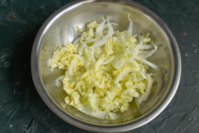 Шинкуем китайскую капусту узкими полосками и перекладываем в глубокую миску. Посыпаем нарезку солью и слегка разминаем руками для мягкости листьев. Шинкуем китайскую капусту узкими полосками и перекладываем в глубокую миску. Посыпаем нарезку солью и слегка разминаем руками для мягкости листьев.