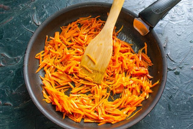 Пока варятся желудки, готовим овощи. Чистим и режем морковь соломкой. Обжариваем её в масле с солью на тихом огне около 10 минут, пока она не станет мягкой.