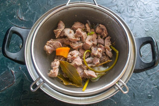 Когда желудки сварятся до полной мягкости, откидываем их на дуршлаг. Вареные коренья и специи из бульона удаляем, они уже отдали свой аромат.