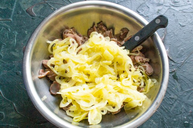 Добавляем в миску к нарезанным желудкам остывший обжаренный лук.