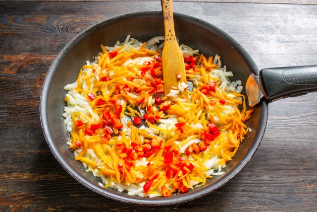 Удаляем у сладкого перца семена, нарезаем мякоть мелкими кубиками. Отправляем перец в сковороду к пассерованным овощам и продолжаем обжаривать вместе