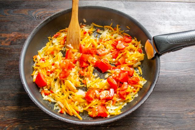 Режем помидоры кубиками и добавляем к овощной зажарке. Вместо свежих плодов можно использовать консервированные томаты или густое томатное пюре.