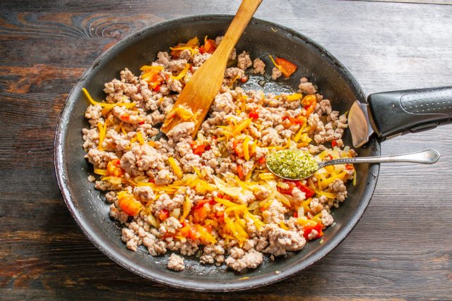 Добавляем сладкую паприку и сушеные травы, тушим начинку на слабом огне 7 минут. Ароматы должны объединиться, а лишняя влага из овощей выпариться.