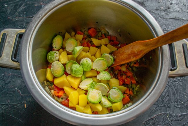 Перекладываем подготовленную брюссельскую капусту в кастрюлю к остальным овощам. На этом этапе овощи полностью готовы к добавлению мясного бульона.