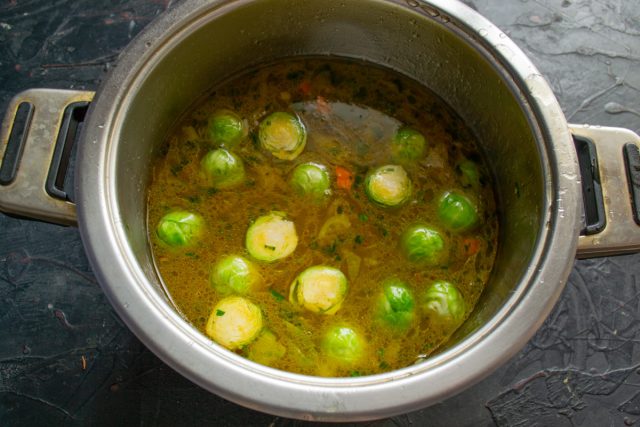 Заливаем овощную базу горячим процеженным куриным бульоном и доводим суп до кипения. Добавляем соль и немного сахара для баланса томатной кислоты.