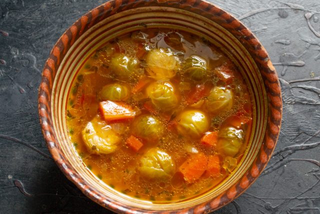 Разливаем горячие щи с брюссельской капустой по глубоким тарелкам. Кладем кусочки отварного куриного мяса, приправляем перцем и подаем со сметаной.