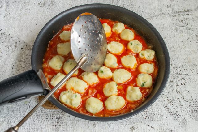 Добавляем томатную пасту, воду, сахар и паприку. Кипятим соус пару минут, затем выкладываем в него отваренные ньокки и прогреваем блюдо одну минуту.