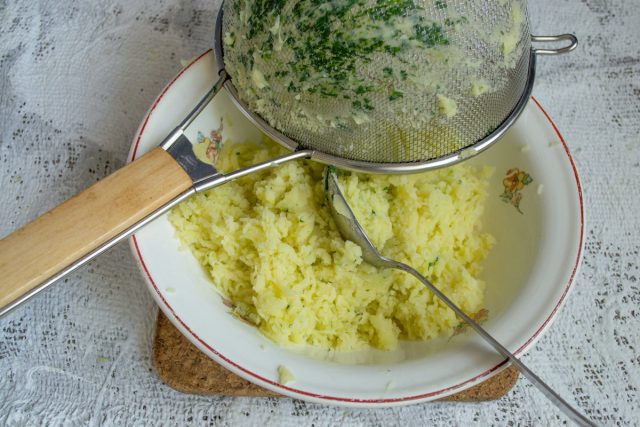 Протираем вареный картофель со шпинатом через сито ложкой или разминаем толкушкой вручную. Исключаем использование блендера, чтобы избежать клейкости.