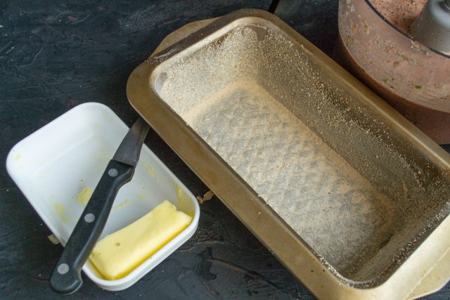 Берем прямоугольную кексовую форму и обильно смазываем ее сливочным маслом. Обсыпаем дно и бортики панировочными сухарями для создания защитного слоя.