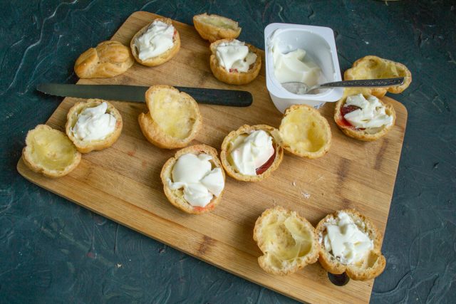 Заполняем пустоты поверх клубники готовым ванильным пудингом или мягким творожком. Используем по две-три чайные ложки густой начинки на одну порцию.