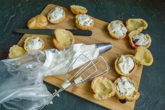 Взбиваем охлажденные жирные сливки миксером до устойчивых пиков. Перекладываем пышную массу в чистый кондитерский мешок с фигурной насадкой звездочка.