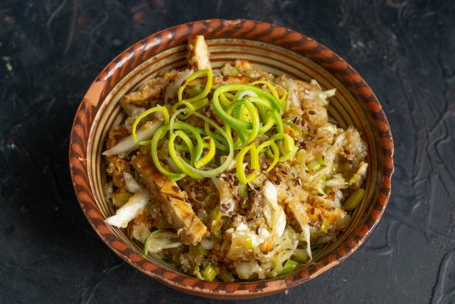 Посыпаем готовое блюдо тонкими кольцами лука-порея и семенами льна. Подаем салат к столу сразу же