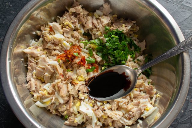 Добавляем к рубленному мясу мелко нарезанную зелень петрушки. Вливаем соевый соус, приправляем черным и красным перцем для пикантности начинки.