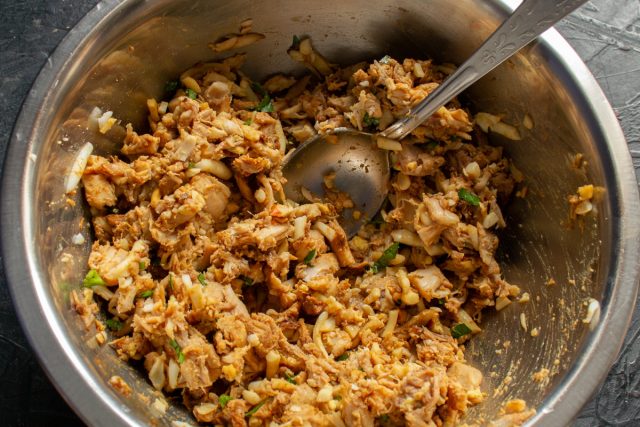 Тщательно перемешиваем начинку ложкой, равномерно распределяя специи и зелень. Пробуем массу на вкус и при необходимости дополнительно солим.