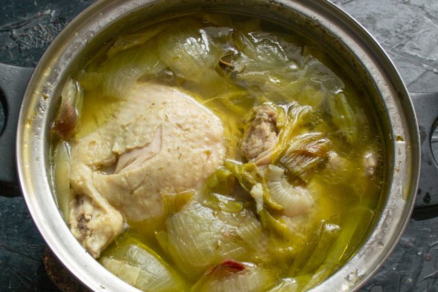 Закладываем курицу со специями и луком в кастрюлю, заливаем водой и варим час. Остужаем готовое мясо прямо в бульоне, чтобы оно осталось сочным.