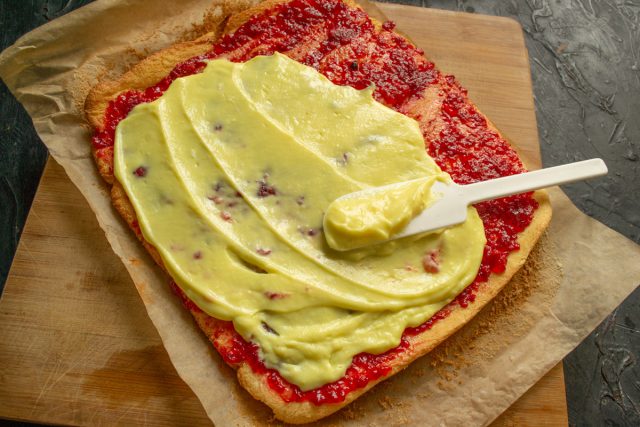 Распределение заварного крема поверх джема