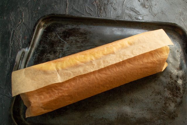 Сворачивание горячего бисквита в рулет с бумагой