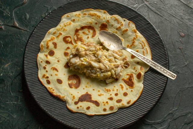 Выкладываем примерно 40 граммов подготовленной начинки в центр блинчика с изнаночной стороны. Равномерно распределяем массу для удобства сворачивания.