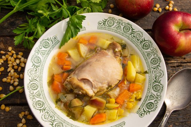 Подача куриного супа с мясом и кукурузой в тарелке