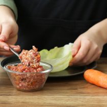 Классическую начинку для голубцов легко сделать летней: к мясу и рису добавляют кабачок, морковь, лук, зелень, грибной порошок или молодые чесночные стрелки.